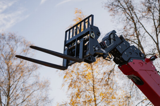 Telescopic handler fork attachment lifting mechanism on hydraulic boom arm used for industrial material handling and construction site logistics