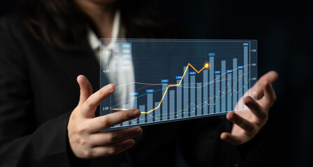 A business professional displays a modern digital graph that illustrates financial growth trends,...