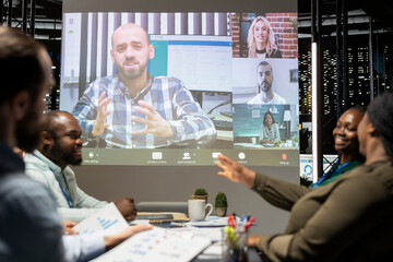 Employees team engaging in strategic planning in a boardroom briefing late at night, using virtual...