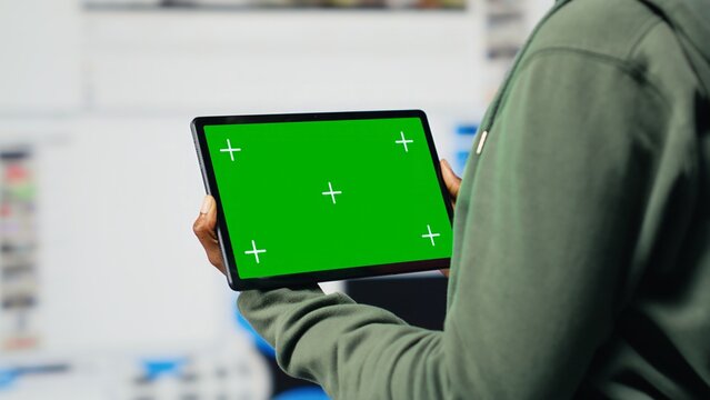 Mockup device used by woman enjoying unlimited metaverse video content. Green screen tablet used by person to look at internet video channels, isolated over digital backdrop