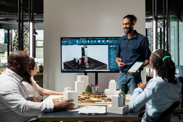 Middle eastern architect showing blueprints and software for construction master plan, briefing...