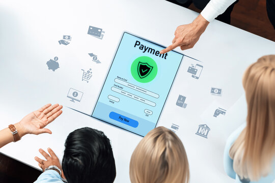Participants actively engage with a digital payment interface on a tablet, highlighting modern payment solutions and security features in a collaborative workspace environment. Trope - Powered by Adobe