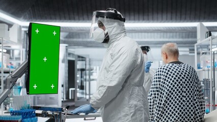 Vertical green screen next to black medic in hazmat suit observing contagious epidemic in lab,...