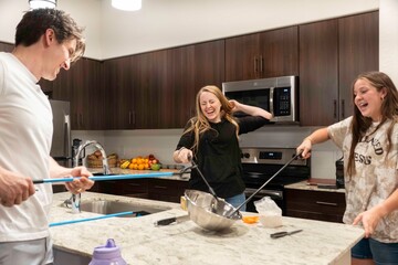 A group of friends enjoying having fun cooking in a modern kitchen