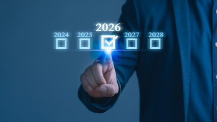 Businessman touch virtual screen with year 2026 check mark, representing future planning, business goals, timeline, innovation strategy, digital transformation, and success vision for upcoming years.