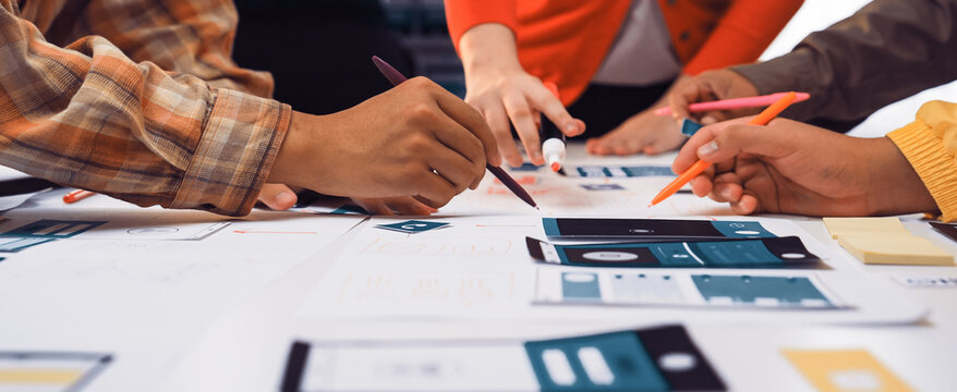 Engaged team members actively discuss and create user interface prototypes during a collaborative workshop, showcasing creativity and teamwork in a modern workspace environment. SACTR