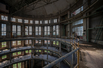 Fototapeta premium Abandoned distillery tower in Italy – circular industrial building with glass dome, steel beams, panoramic windows, decaying factory interior, urban exploration, post-industrial architecture