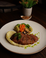 Grilled Beef Steak with Mashed Potatoes and Steamed Vegetables on Ceramic Plate
