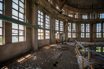 Abandoned distillery tower in Italy – circular industrial building with glass dome, steel beams, panoramic windows, decaying factory interior, urban exploration, post-industrial architecture