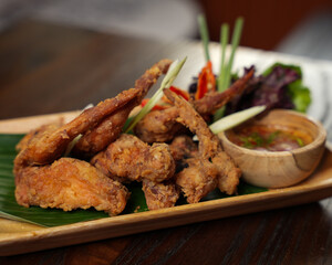 Crispy Fried Chicken Wings with Thai Spicy Dipping Sauce on Wooden Platter