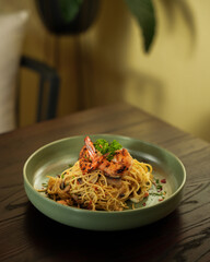 Spaghetti Aglio Olio with Grilled Shrimp and Mushroom Served in Green Ceramic Bowl