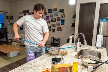 Home Cooking: Young Man Mixing Ingredients in Modern Kitchen