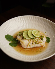 Steamed Fish Fillet with Lime and Ginger Sauce Served in Ceramic Bowl