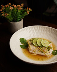 Steamed Fish Fillet with Lime and Ginger Sauce Served in Ceramic Bowl