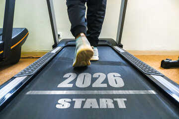 A person walking on a treadmill with the text 2026 START on it. New year fitness a healthy lifestyle and new fitness goals for the new year.