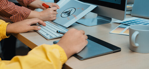 A bright modern office showcases a creative workspace where individuals collaborate on graphic design projects using digital tools, sketches, and technology. SACTR