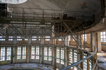 Obraz premium Abandoned distillery tower in Italy – circular industrial building with glass dome, steel beams, panoramic windows, decaying factory interior, urban exploration, post-industrial architecture