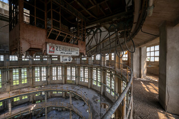 Abandoned distillery tower in Italy – circular industrial building with glass dome, steel beams, panoramic windows, decaying factory interior, urban exploration, post-industrial architecture