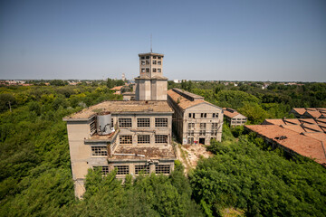 Abandoned distillery tower in Italy – circular industrial building with glass dome, steel beams, panoramic windows, decaying factory interior, urban exploration, post-industrial architecture