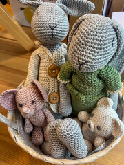 Hand-made knitted toys in a cozy basket, featuring adorable rabbits and a mouse, showcasing eco-friendly craftsmanship and comfort for kids, perfect for imaginative play