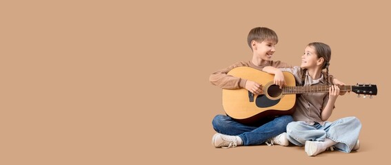 Little children playing guitar on beige background with space for text