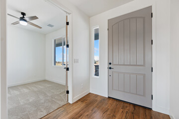 An empty room featuring a ceiling fan and a gray door on display