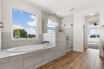 Fototapeta premium A beautifully designed bathroom featuring a bathtub and a window