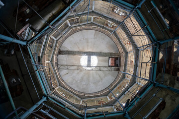 Abandoned distillery tower in Italy – circular industrial building with glass dome, steel beams, panoramic windows, decaying factory interior, urban exploration, post-industrial architecture