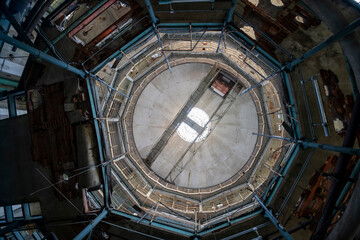 Abandoned distillery tower in Italy – circular industrial building with glass dome, steel beams, panoramic windows, decaying factory interior, urban exploration, post-industrial architecture