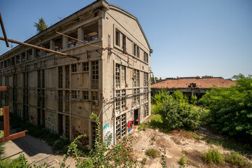 Fototapeta premium Abandoned distillery tower in Italy – circular industrial building with glass dome, steel beams, panoramic windows, decaying factory interior, urban exploration, post-industrial architecture