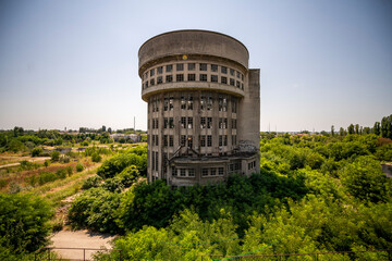 Abandoned distillery tower in Italy – circular industrial building with glass dome, steel beams, panoramic windows, decaying factory interior, urban exploration, post-industrial architecture