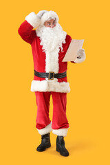 Shocked Santa Claus reading letter on yellow background