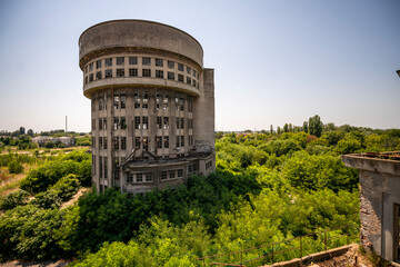Abandoned distillery tower in Italy – circular industrial building with glass dome, steel beams, panoramic windows, decaying factory interior, urban exploration, post-industrial architecture