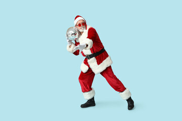Santa Claus in sunglasses with disco ball on blue background