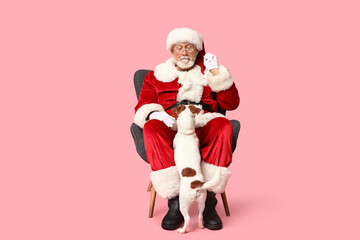 Santa Claus with cute Jack Russell Terrier dog on pink background