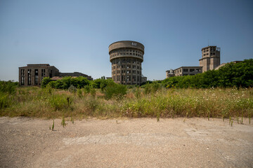 Abandoned distillery tower in Italy – circular industrial building with glass dome, steel beams, panoramic windows, decaying factory interior, urban exploration, post-industrial architecture