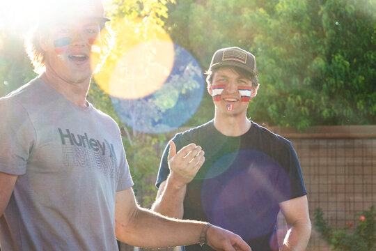 Two men stand together side by side one of them wears a hurley shirt