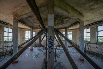 Abandoned distillery tower in Italy – circular industrial building with glass dome, steel beams, panoramic windows, decaying factory interior, urban exploration, post-industrial architecture