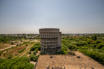 Abandoned distillery tower in Italy – circular industrial building with glass dome, steel beams, panoramic windows, decaying factory interior, urban exploration, post-industrial architecture
