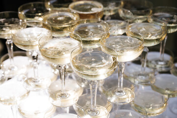 Close-up view of elegant champagne glasses filled with sparkling wine, glistening in the light during a festive celebration or special event.
