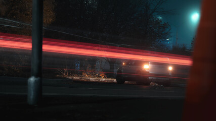 A car with its hazard lights on on a city street at night