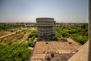 Abandoned distillery tower in Italy – circular industrial building with glass dome, steel beams, panoramic windows, decaying factory interior, urban exploration, post-industrial architecture