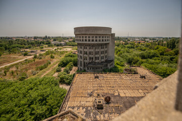 Abandoned distillery tower in Italy – circular industrial building with glass dome, steel beams, panoramic windows, decaying factory interior, urban exploration, post-industrial architecture