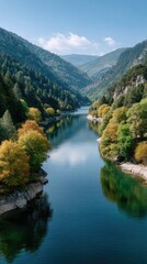 Fototapeta premium Serene Lake Reflecting Majestic Forested Mountains Under a Clear Blue Sky with Autumn Foliage on the Shores