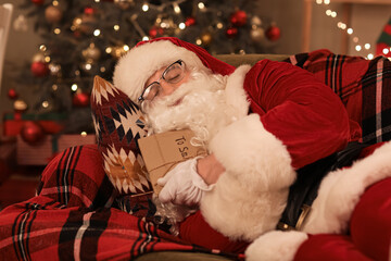 Obraz premium Santa Claus with letters sleeping at home on Christmas eve