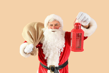 Santa Claus with bag and Christmas lantern on beige background