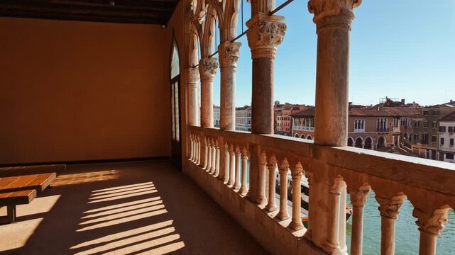 Cinematic view of the Grand Canal seen through a beautiful loggia in Venice, Veneto, Italy
