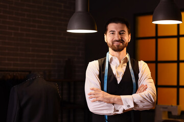 Male tailor smiling in atelier at night