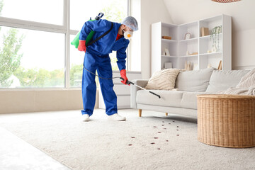 Male pest control specialist carrying out cockroach disinfection in room