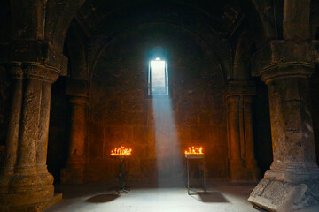 A church Haghartsin Monastery. A dark room with a window and two candles lit